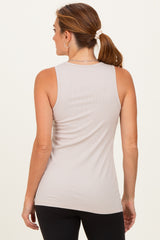 woman wearing a beige ribbed tank top, seen from the back, paired with black leggings
