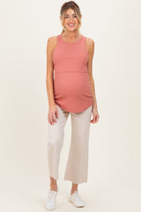 woman wearing a dusty rose ribbed maternity tank top and light beige cropped pants, showing her baby bump
