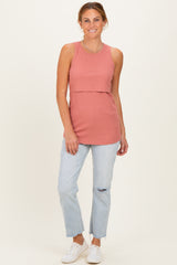 woman wearing a rust-colored ribbed sleeveless top with a layered effect and light blue distressed jeans