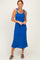 woman wearing a bright blue knit midi dress with tie-straps and a relaxed fit, standing with arms crossed