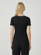 woman wearing a black ribbed short sleeve top, shown from the back, paired with black pants