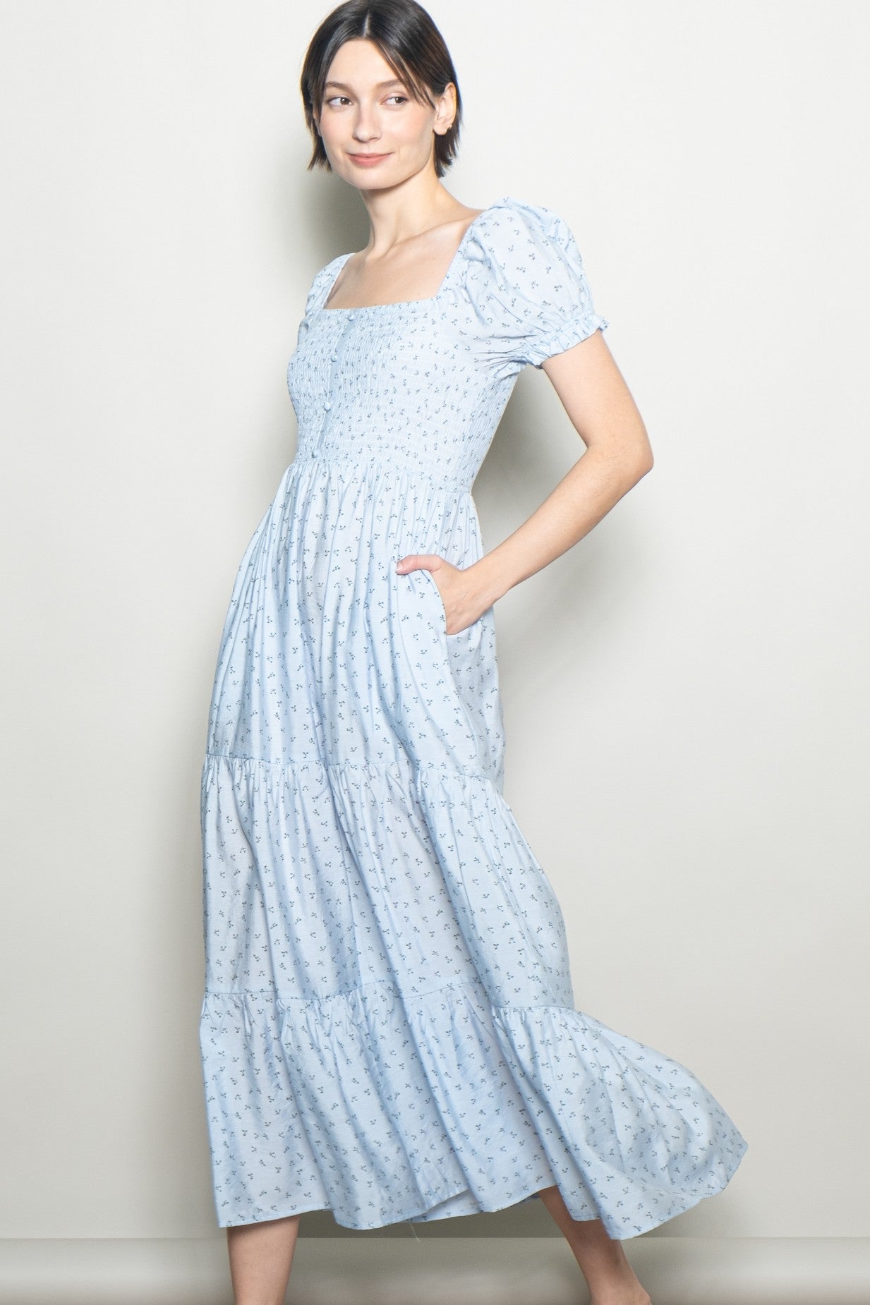 woman wearing a light blue floral maxi dress with puff sleeves and side pockets