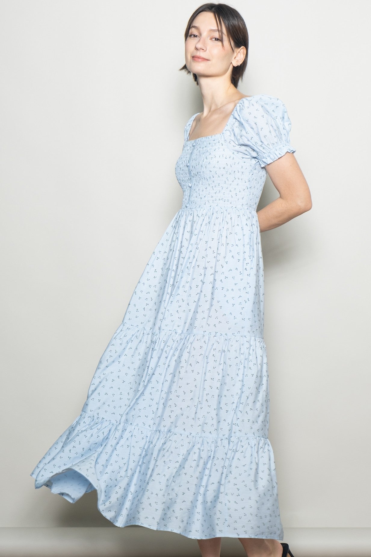 woman wearing a light blue floral maxi dress with puff sleeves and a fitted bodice