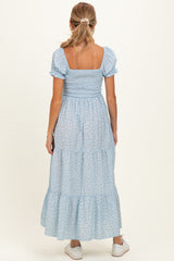 woman wearing a light blue maternity maxi dress with smocked bodice and puff sleeves, viewed from the back