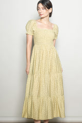 woman wearing a yellow floral print square neck maxi dress with puff sleeves and tiered skirt