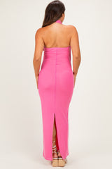 woman wearing a pink halter neck maternity gown with a back slit and body-hugging fit