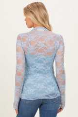 woman wearing a light blue long sleeve lace maternity top, showing a floral pattern from the back
