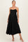 woman wearing a black maternity dress with a sweetheart neckline and pleated skirt, showing her baby bump