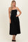 woman wearing a black spaghetti strap midi dress with a fitted bodice and flowy skirt