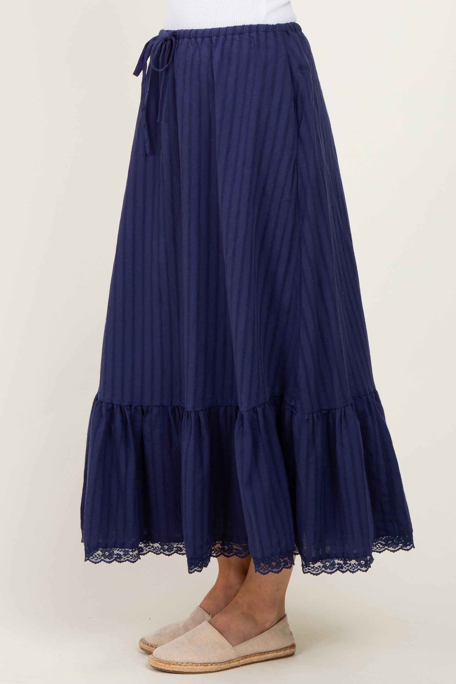 navy blue maxi skirt with vertical stripes and lace trim at the hem, featuring a drawstring waist