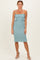woman wearing a teal smocked midi dress with ruffle details and spaghetti straps, paired with beige heeled sandals