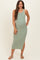woman wearing a green ribbed maternity maxi dress with side slits and a fitted style, showing her baby bump