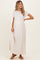 woman wearing a cream maternity maxi dress with short sleeves and an empire waist, showing her baby bump