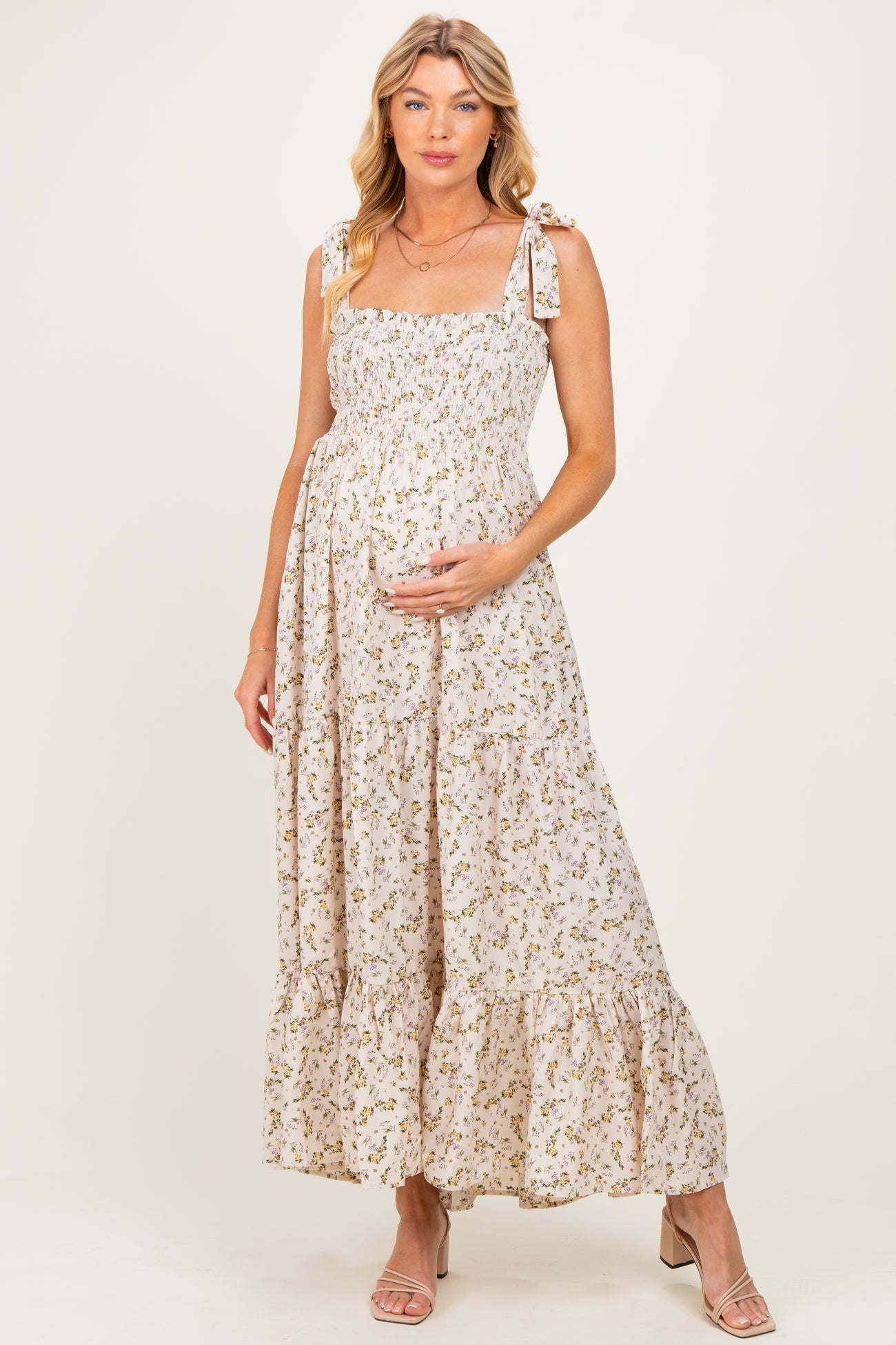 woman wearing a floral maternity maxi dress with tie straps and a baby bump visible