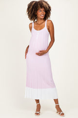 woman wearing a pink and white striped maternity maxi dress and holding her baby bump