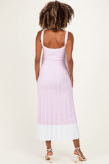 woman wearing a light pink and white striped maternity dress with a fitted silhouette and spaghetti straps, viewed from the back