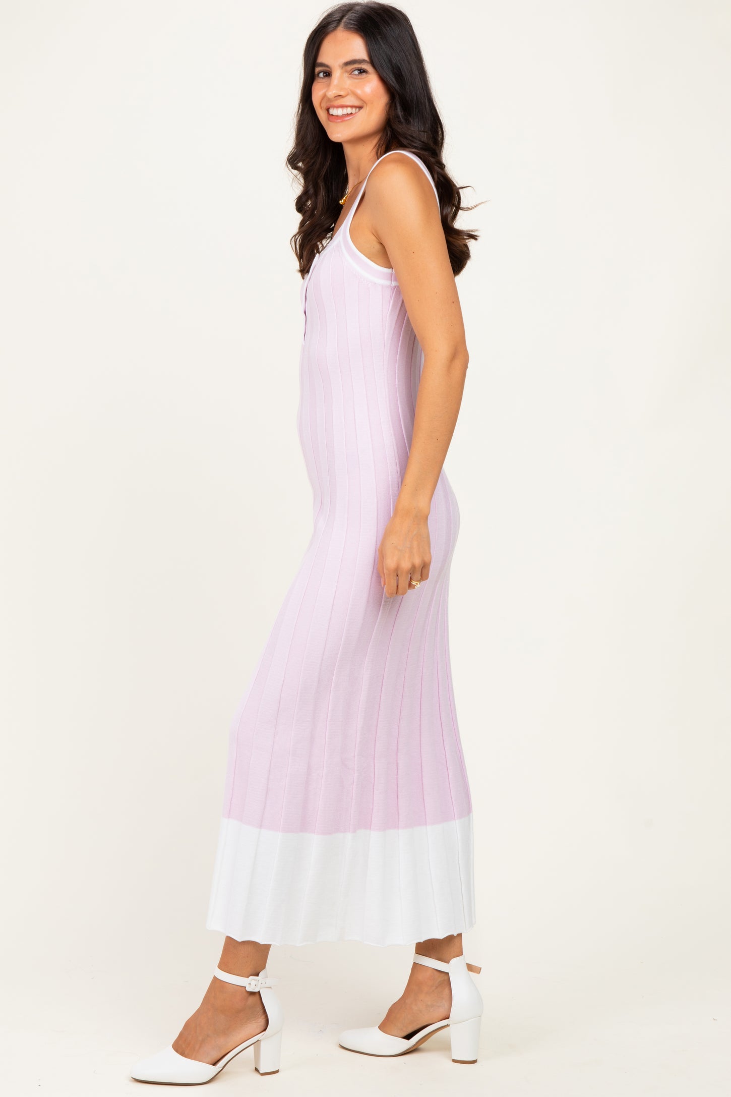 woman wearing a light purple ribbed maxi dress with a white hem and buttons, styled with white heels