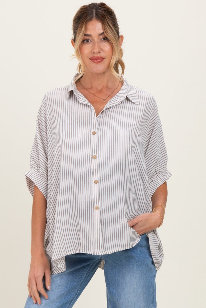 woman wearing a striped short sleeve maternity blouse with buttons, styled with rolled sleeves, paired with light wash jeans