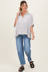 woman wearing a striped maternity top with short sleeves and jeans walking confidently.