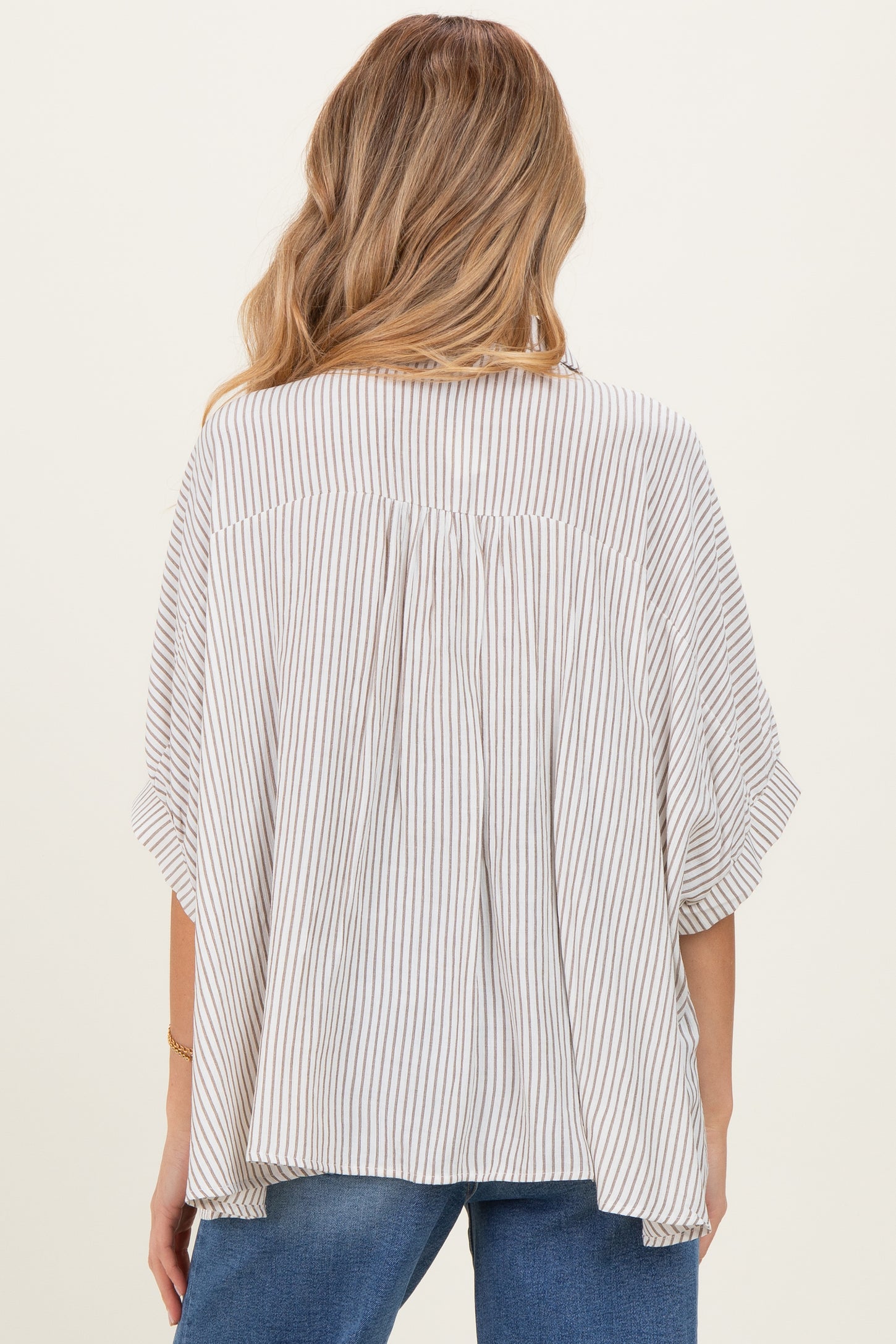 woman wearing a striped maternity top with loose fit and short sleeves, showing the back design