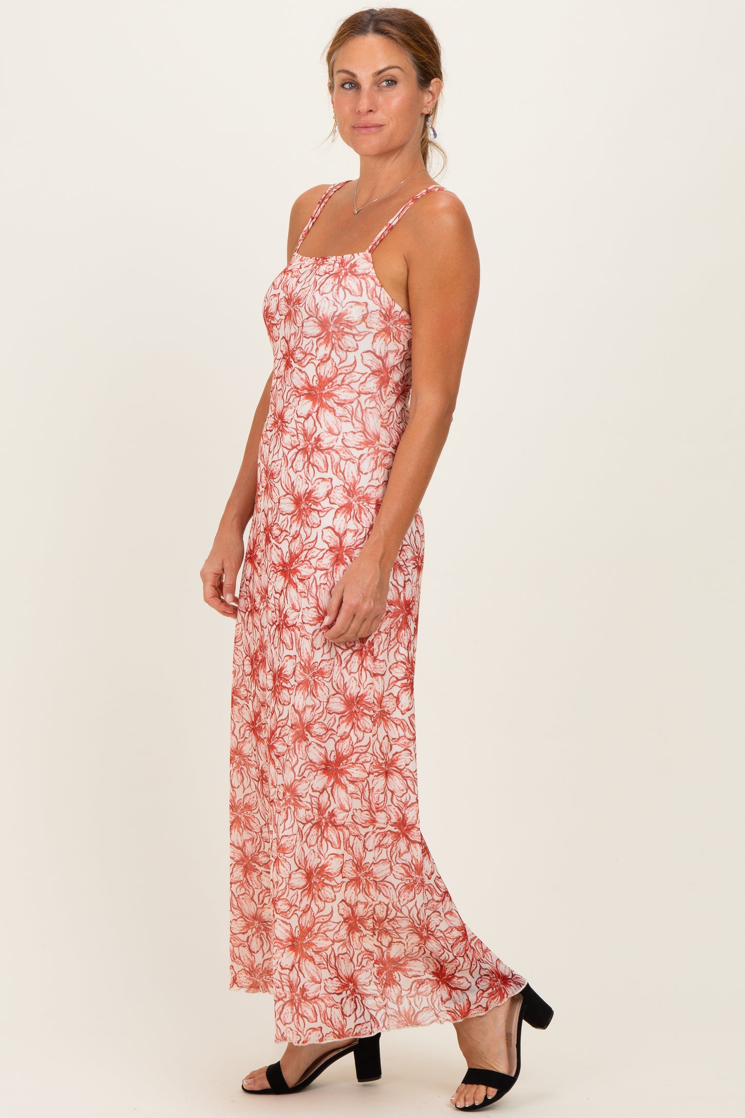 woman wearing a floral red and white maxi dress with thin straps and a relaxed fit