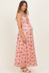 woman wearing a red floral maternity maxi dress with adjustable straps and showing her baby bump