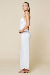 woman wearing a white ribbed maxi dress with spaghetti straps and a form-fitting silhouette