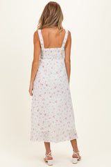 woman wearing a white floral print maternity dress with a fitted bodice and flowing skirt, showing her back