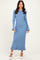 woman wearing a ribbed light blue maxi dress with flared sleeves and ruffle hem, paired with white heels