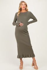 woman wearing a green ribbed maternity dress with a ruffled hem and holding her baby bump