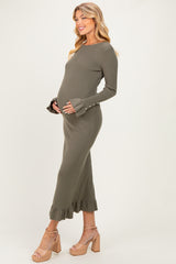 woman wearing a dark olive long sleeve maternity dress with ruffle hem and bell sleeves, holding her baby bump