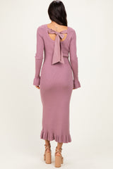 woman wearing a lavender ribbed midi dress with a tie back and ruffle hem, showcasing her back and legs