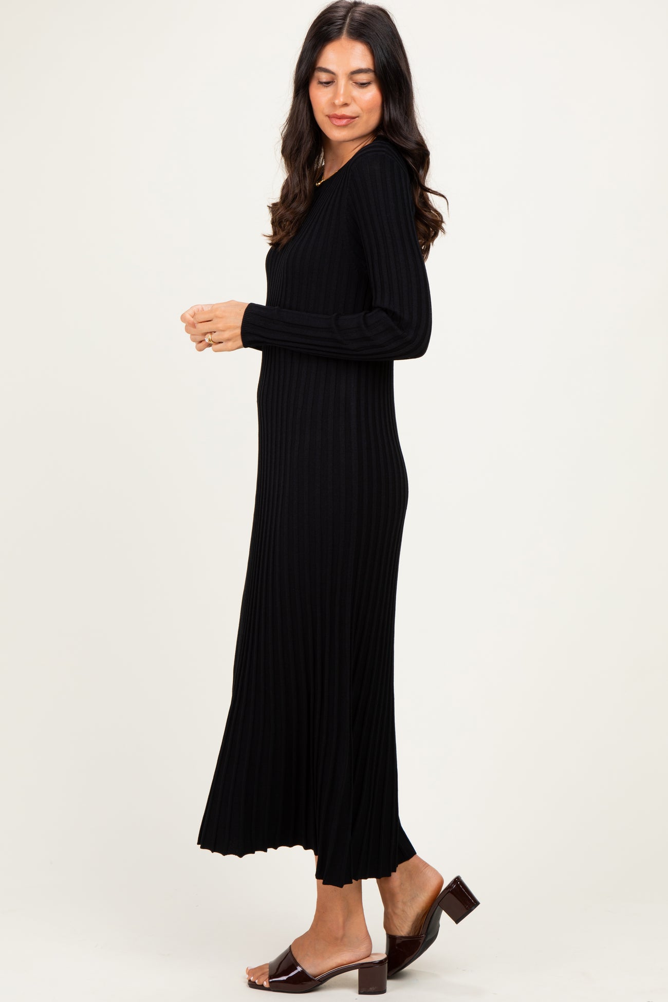 woman wearing a black ribbed knit long sleeve midi dress and brown heeled sandals