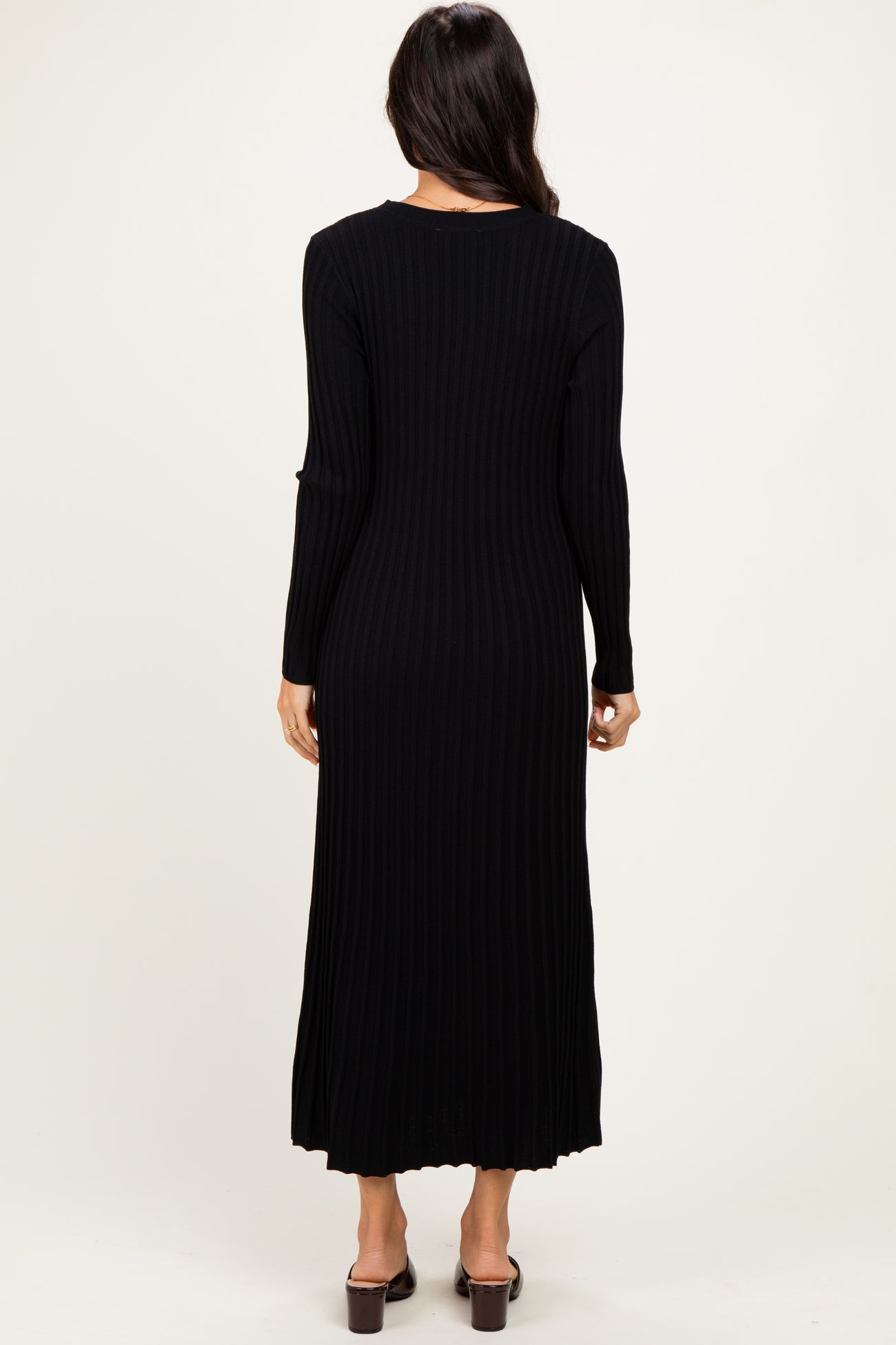 woman wearing a black ribbed long sleeve maxi dress, shown from the back