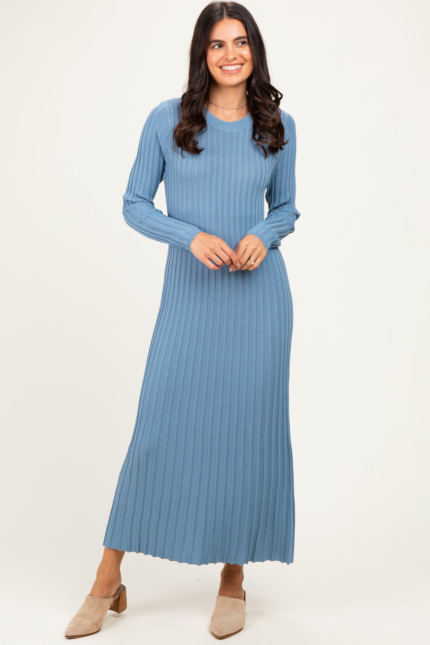 woman wearing a ribbed blue long sleeve maxi dress with side slits and heels