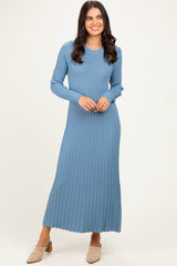 woman wearing a ribbed blue long sleeve maxi dress with side slits and heels