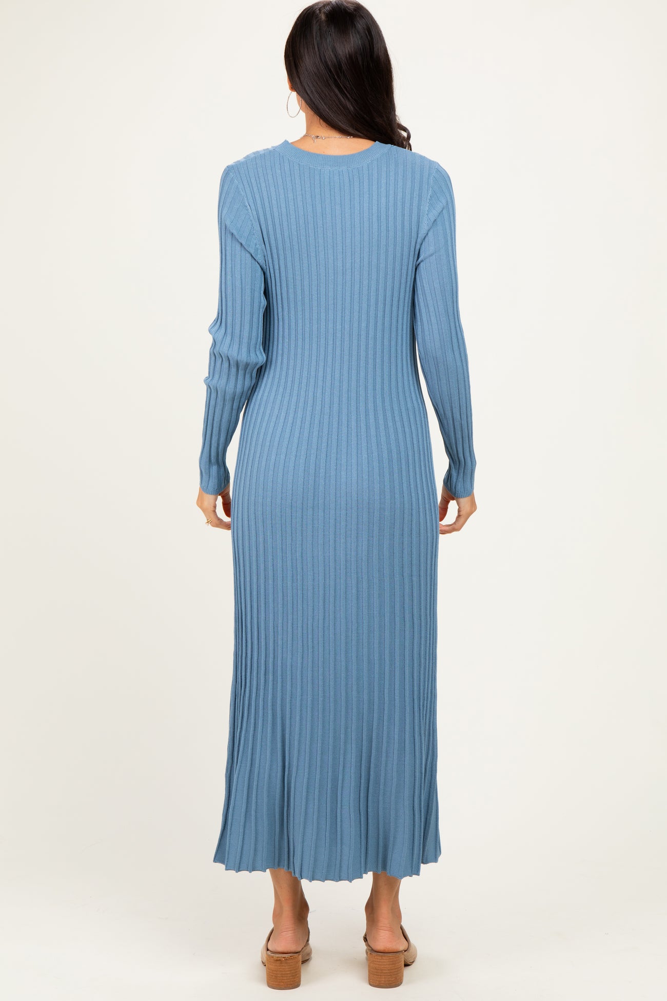 woman wearing a long sleeve ribbed blue maxi dress, seen from the back