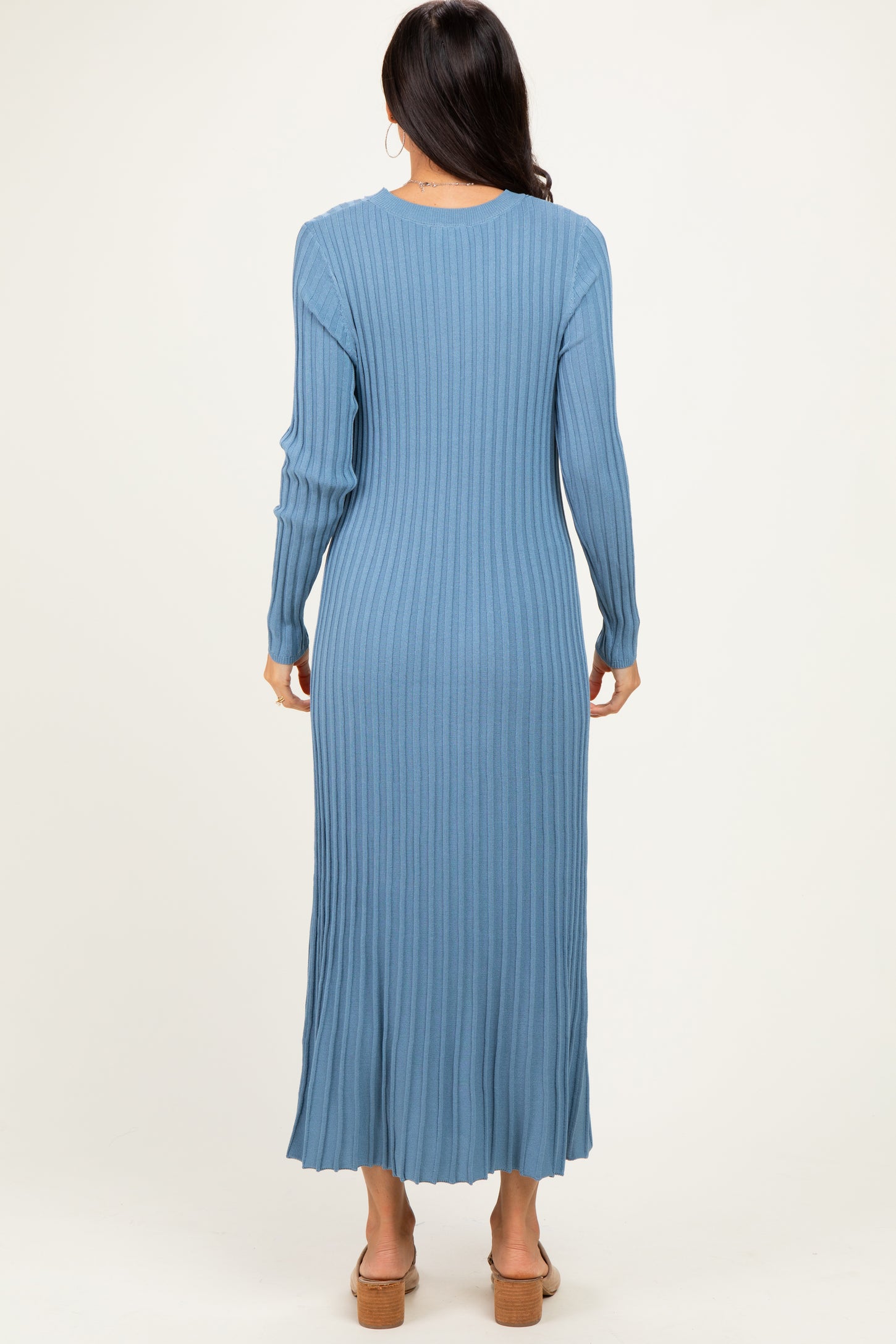 woman wearing a long sleeve ribbed blue maxi dress, seen from the back