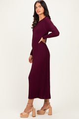 woman wearing a burgundy ribbed long sleeve maxi dress with a fitted silhouette and side slit, paired with beige heeled sandals