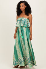 woman wearing a green patterned strapless maxi dress with ruffled top and drawstring waist