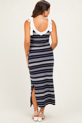 woman wearing a striped navy and gray maternity maxi dress with white tie straps and a side slit, showing her baby bump