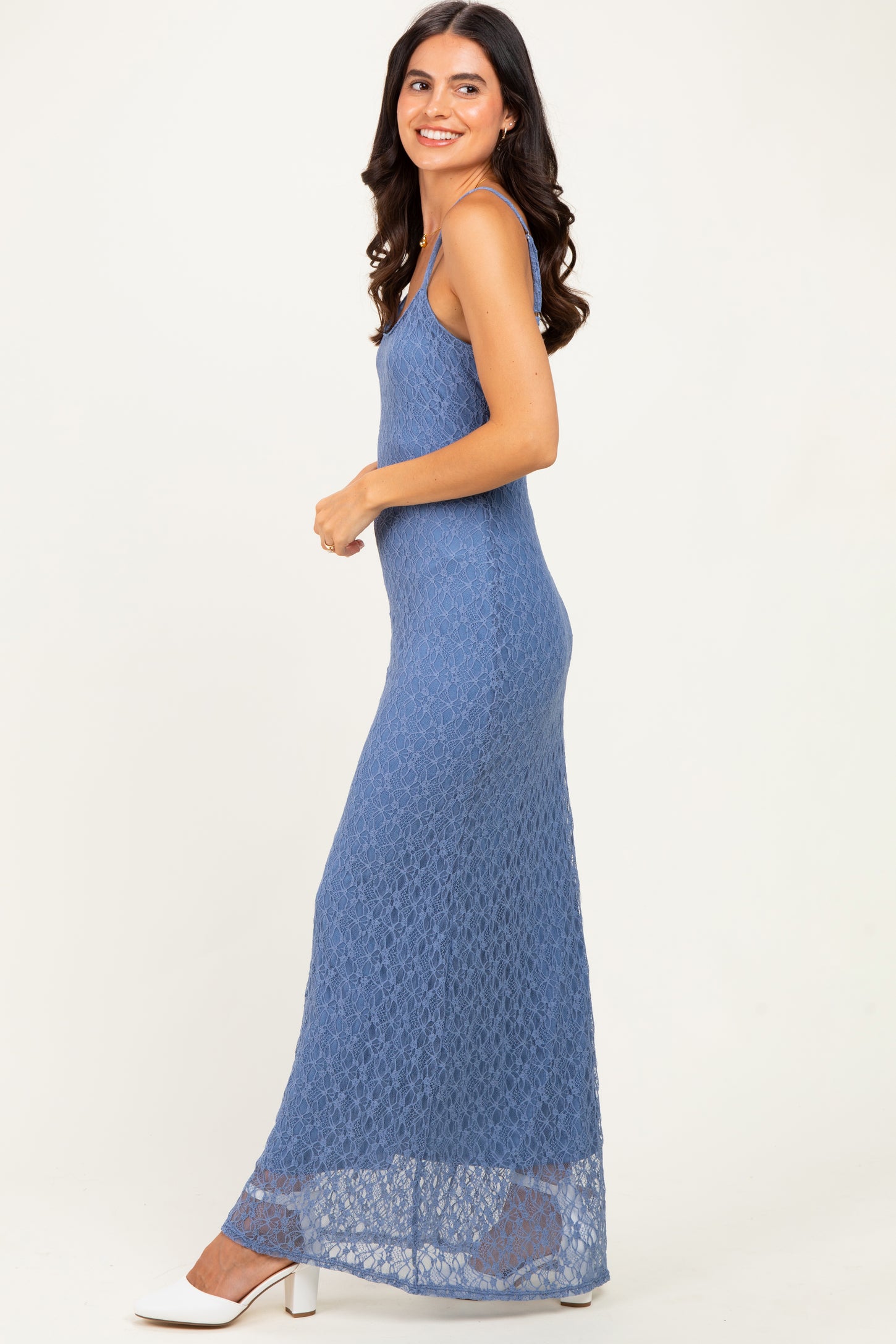 woman wearing a blue lace maxi dress with spaghetti straps and a fitted silhouette
