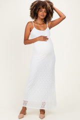 woman wearing a white lace maternity maxi dress and holding her baby bump