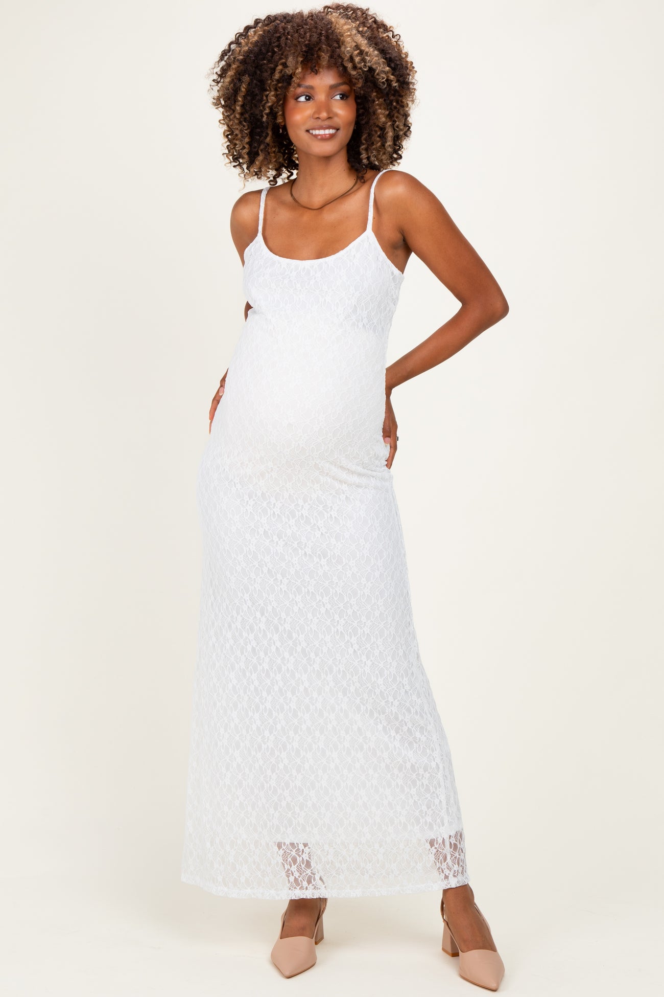 woman wearing a white lace maternity maxi dress and showing her baby bump
