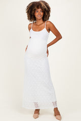 woman wearing a white lace maternity maxi dress and showing her baby bump