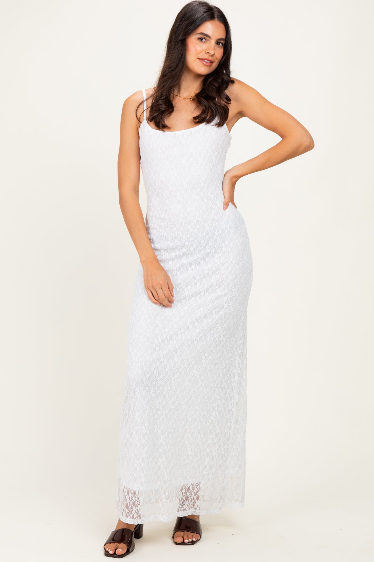 woman wearing a white lace maxi dress with thin straps and a fitted silhouette