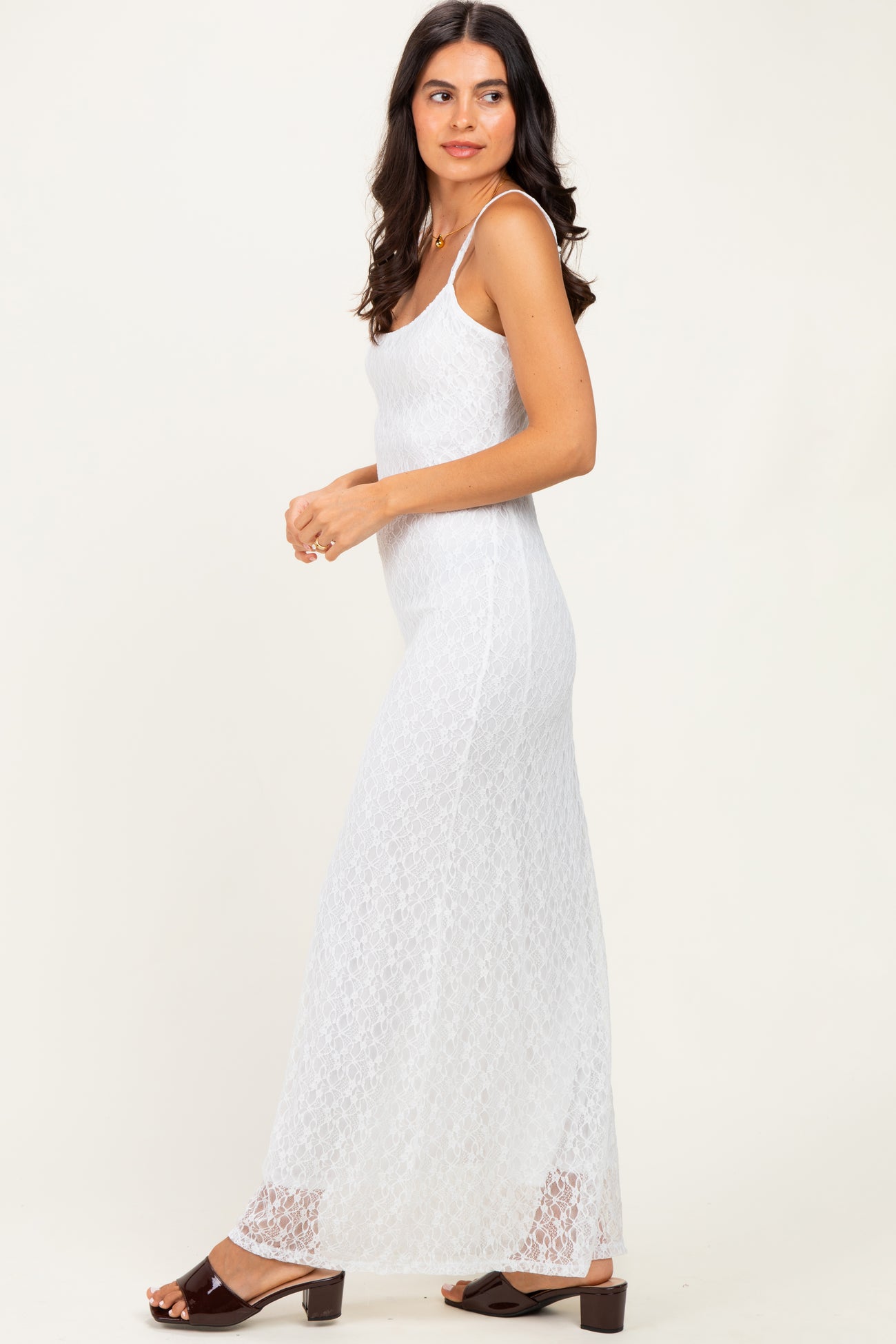 woman wearing a white lace maxi dress with a fitted silhouette and a scoop neckline