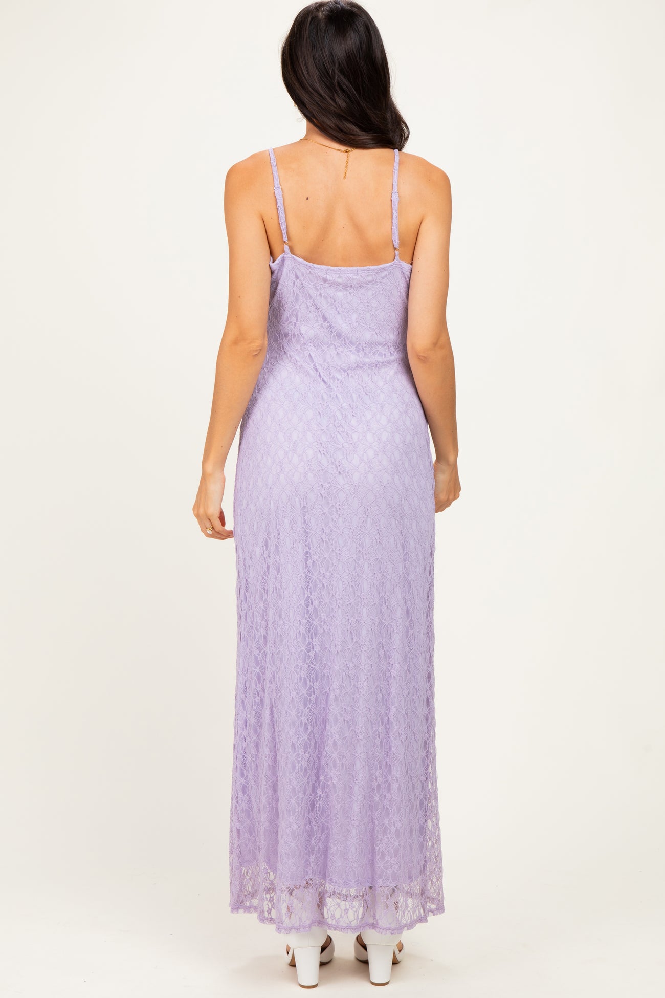 woman wearing a lavender lace maxi dress with spaghetti straps, showing a fitted silhouette from the back