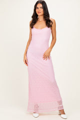 woman wearing a pink crochet maxi dress with thin straps and a fitted silhouette