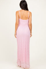 woman wearing a pink lace maxi dress with thin straps, showing the back view
